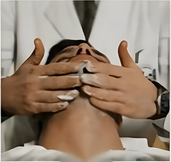 Le mani del barbiere sul viso di un cliente, durante il massaggio